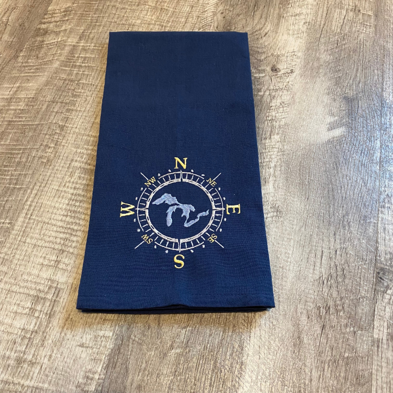 This beautiful navy blue tea towel features a Great Lakes design embroidered within a compass face.