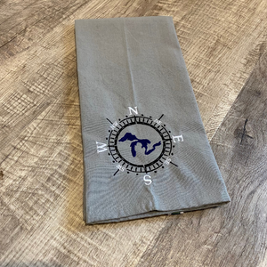 This beautiful grey tea towel features a Great Lakes design embroidered within a compass face.
