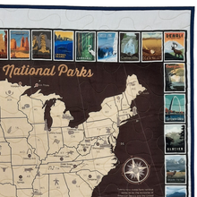 Load image into Gallery viewer, Commemorate your love of the National Parks with this handmade quilted wall hanging. The intricate design is crafted to last, becoming a timeless addition to any home decor or as a treasured gift.   Easily commemorate your travels with additional hand-stitching or pins.  This panel features a map of the national parks in the United States of America bordered by national park posters. Made in Wisconsin, USA by AdventureUs